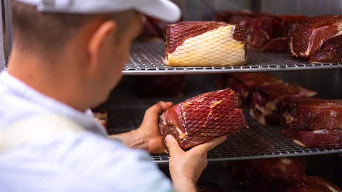 Mitarbeiter in der Reifung mit einem Stück Fleisch